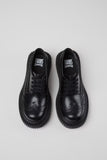 Top view of Camper Twins black leather shoes showing the complementary differences between the pair